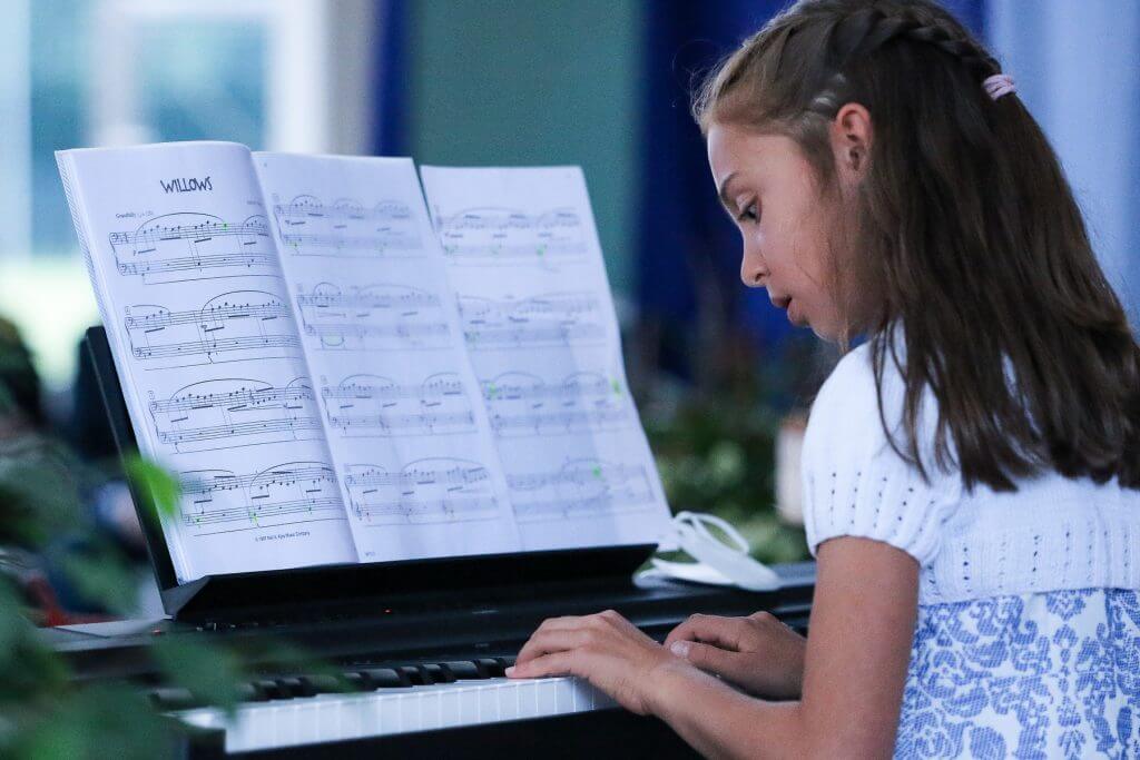 Una giovane studentessa che suona il pianoforte