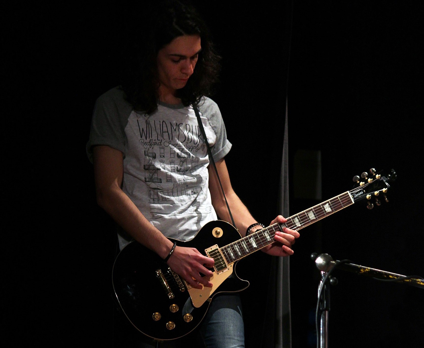 Un giovane studente che suona la chitarra elettrica durante un concerto di presentazione