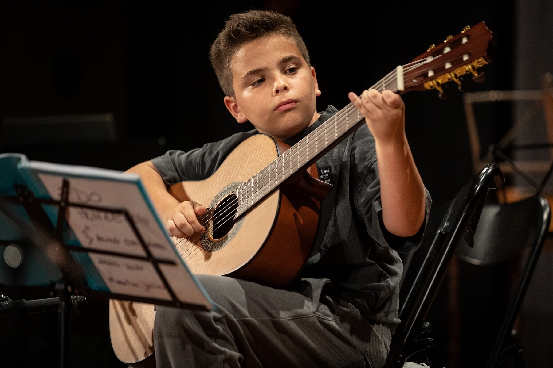 Un giovane studente che suona uno strumento musicale durante un concerto di presentazione